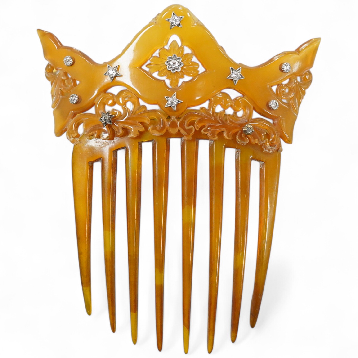 An early 20th century tortoiseshell hair comb set with eleven diamonds, 99mm by 83mm.